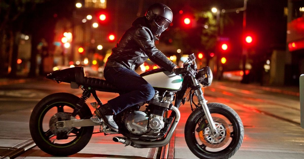 motorcycle rider driving across a train track