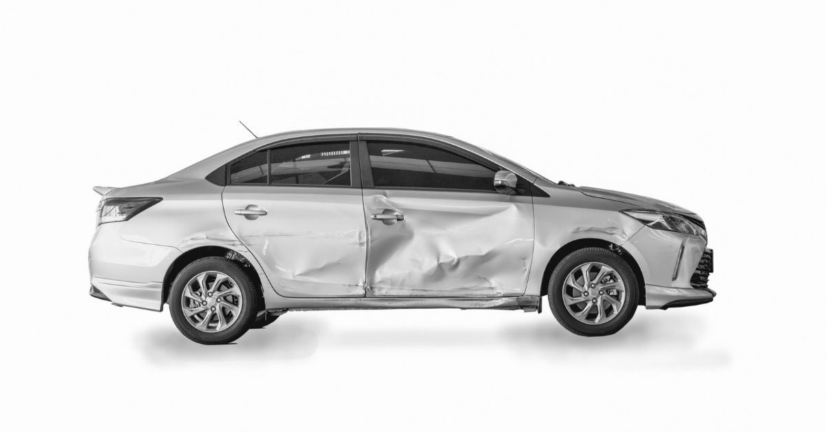 damaged silver car on a white background